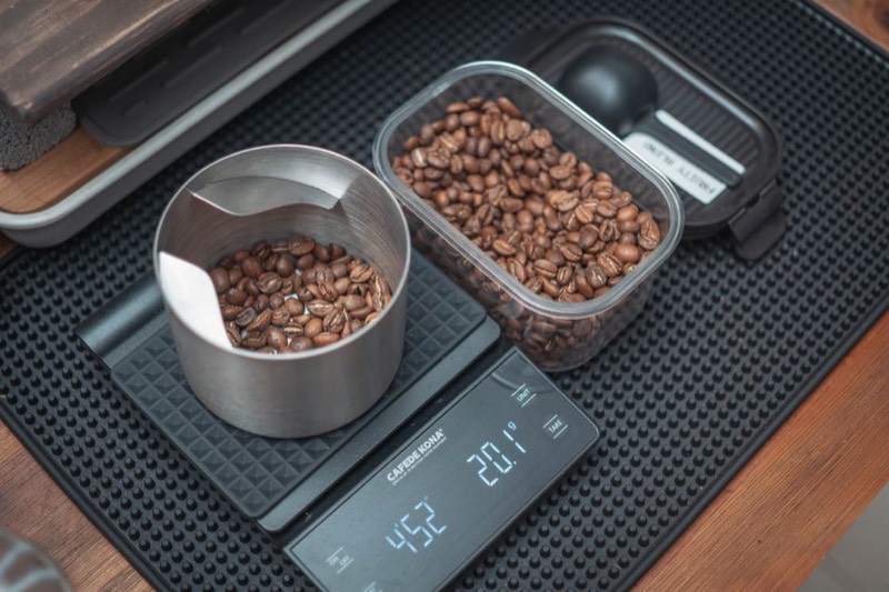 Espresso pouring into a glass measuring cup showing extraction volume and crema