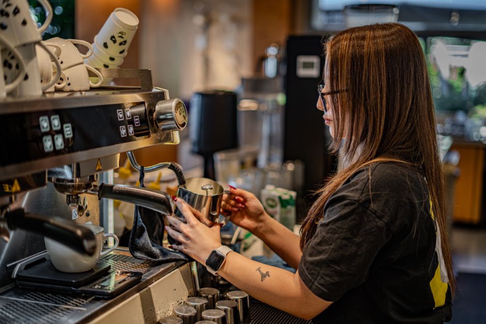 Barista steaming milk at a prosumer espresso machine